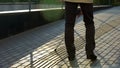 Visually impaired man with cane walking on special tactile paving for blind