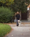 Visually impaired woman walking in park with a guide dog assistance Royalty Free Stock Photo