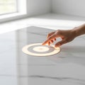 A photorealistic close-up shows a human hand, cropped at wrist, smoothly adjusting a glowing circular smart home control panel set Royalty Free Stock Photo