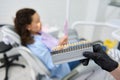 Vita scale. Bleaching teeth guide. Tooth color chart in dentist& x27;s hands over blurred patient in dental chair Royalty Free Stock Photo