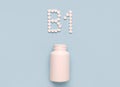 Vitamin B1, thiamine icon from tablets and drug bottle on blue background.