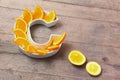 Vitamin C or ascorbic acid nutrient in food concept. Plate in shape of letter C with orange slices on wooden background. Flatlay