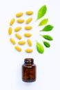 Vitamin C bottle and pills with  green leaves on white Royalty Free Stock Photo