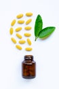 Vitamin C bottle and pills with  green leaves on white Royalty Free Stock Photo