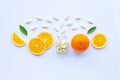 Vitamin C bottle and pills with orange fruit on white Royalty Free Stock Photo