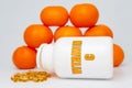 Vitamin C bottle with scattered softgel and oranges. Isolated on white background. Healthy immune system