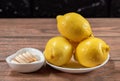 Vitamin c and lemons in a bowl on a wooden table