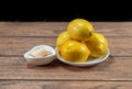 Vitamin c and lemons in a bowl on a wooden table