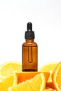 Vitamin C serum in an amber bottle with a pipette on a background of orange citrus fruits. Citrus essential oil, aromatherapy Royalty Free Stock Photo