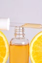 Vitamin C serum in cosmetic bottle with orange citrus slices with on white background. Citrus essential oil, cosmetics Royalty Free Stock Photo