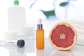 Vitamin C serum in the orange glass cosmetic bottle close up with a grapefruit Royalty Free Stock Photo