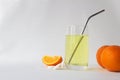 Vitamin C soluble effervescent tablets in a glass of water with a stainless straw. Orange. The drink enhances immunity