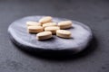 Vitamin C tablets on dark stone background. Soft focus. Royalty Free Stock Photo