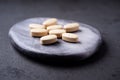 Vitamin C tablets on dark stone background. Soft focus. Royalty Free Stock Photo