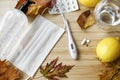 Vitamin D, vitamin C and zinc pills on wooden table with face mask, lemons, fall leaves