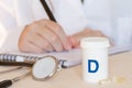 Vitamin D in capsules, stethoscope and doctor in background, health and immunity concept