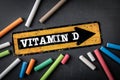 Vitamin D. Direction arrow with text on a dark chalkboard background