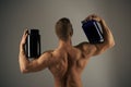 Vitamin diet and sport nutrition. Strong man hold supplement bottles. Muscular man with vitamin supplements