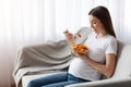 Vitamin Food. Happy Pregnant Woman Eating Vegetable Salad While Sitting On Couch Royalty Free Stock Photo