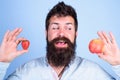 Vitamin fruit nutrition concept. Healthcare dieting vitamin. Man bearded smiling holds apple and strawberry in hands