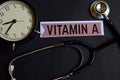 Vitamin A on the paper with Healthcare Concept Inspiration. alarm clock, Black stethoscope.