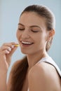 Vitamin. Smiling woman taking omega pill, fish oil supplement Royalty Free Stock Photo