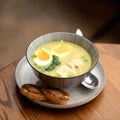 Vitamin soup. Meat Broth with chicken fillet, greens, eggs and croutons. Bowl on wooden table.Close-up shot. Soft focus