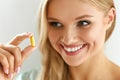 Vitamin And Supplement. Beautiful Woman Holding Fish Oil Capsule Royalty Free Stock Photo