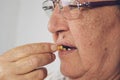 Vitamin And Supplement. Closeup Of Beautiful Old Woman Taking Yellow Fish Oil Pill Royalty Free Stock Photo