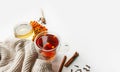 Vitamin tea with berries, honey, Rowan and sea buckthorn berries, cinnamon sticks and dry cloves on light table with knitted beige