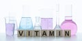 Vitamin word from cubes on background.