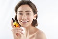 Pretty smiling female holding bottle with oil