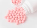 Vitamins. Antiviral drug tablets. Antidepressant. Round pink healthy pills and pill bottle on white background Royalty Free Stock Photo