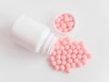 Vitamins. Antiviral drug tablets. Antidepressant. Round pink healthy pills and pill bottle on white background