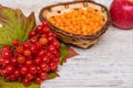 Vitamins Of Autumn. Viburnum, Sea Buckthorn, Red Apple, Close-up On A Light Textured Wooden Background.