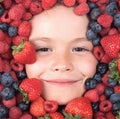 Vitamins from berrie. Child face with berry frame, close up. Berries mix blueberry, raspberry, strawberry, blackberry Royalty Free Stock Photo