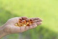 Vitamins in a hand on natural light background.