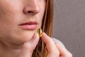 Vitamins and supplements. Close-up of a young woman with freckles taking spilled yellow fish oil. The concept of healthy nutrition Royalty Free Stock Photo