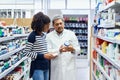 These vitamins will add a great boost to your wellness. a pharmacist assisting a young woman in a chemist.