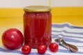 Vitamins on yellow table, tomato, cherry and tomato paste in glass jar and can opener on striped towel Royalty Free Stock Photo