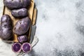 Vitelotte raw potato on a chopping Board. Gray background. Top view. Space for text Royalty Free Stock Photo