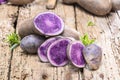Vitolette noir or purple potato. On a wooden background.