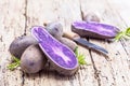 Vitolette noir or purple potato. On a wooden table.