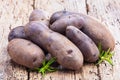 Vitolette noir or purple potato. On a wooden table.