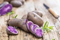 Vitolette noir or purple potato. On a wooden table.