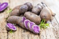 Vitolette noir or purple potato. On a wooden table.