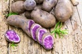 Vitolette noir or purple potato. On a wooden table.