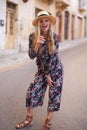 Vivacious blonde Mediterranean woman floral pattern dress posing