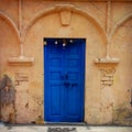 Vivid blue door in peach building in Rishikesh India