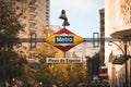 Vivid color image of a city street featuring a hanging metro sign